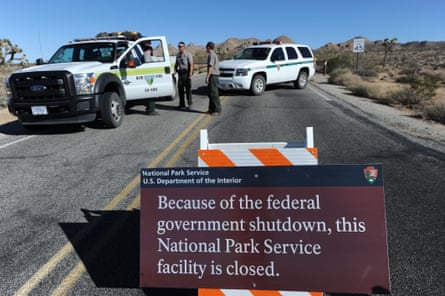 Park rangers stand at the closed gate to Joshua tree national park.