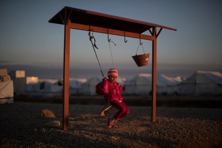 A displaced Iraqi girl, who fled fighting between Iraqi security forces and Isis militants, balances on a swing at the Hassan Sham camp, east of Mosul.