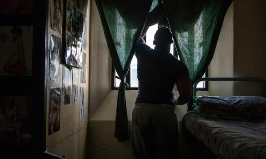 A prisoner stands at his cell window