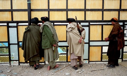 Militiamen on the sun terrace used by the late Taliban leader Mullah Omar in his compound outside the city of Kandahar after the fall of the Taliban in December 2001