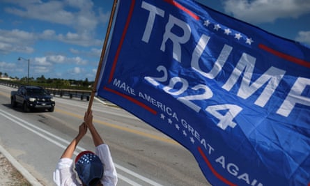 A Trump supporter waves a flag outside Mar-a-Lago in Florida on 22 March.