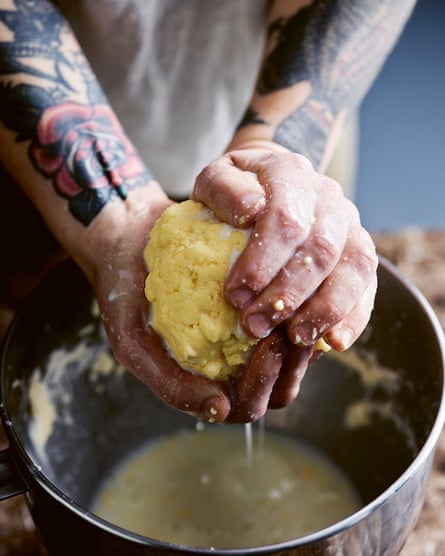 A ball of freshly made butter being squeezed by two hands.