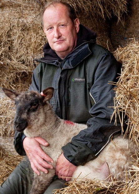 Jonathan Huntley, a sheep and cattle farmer, with one of his flock