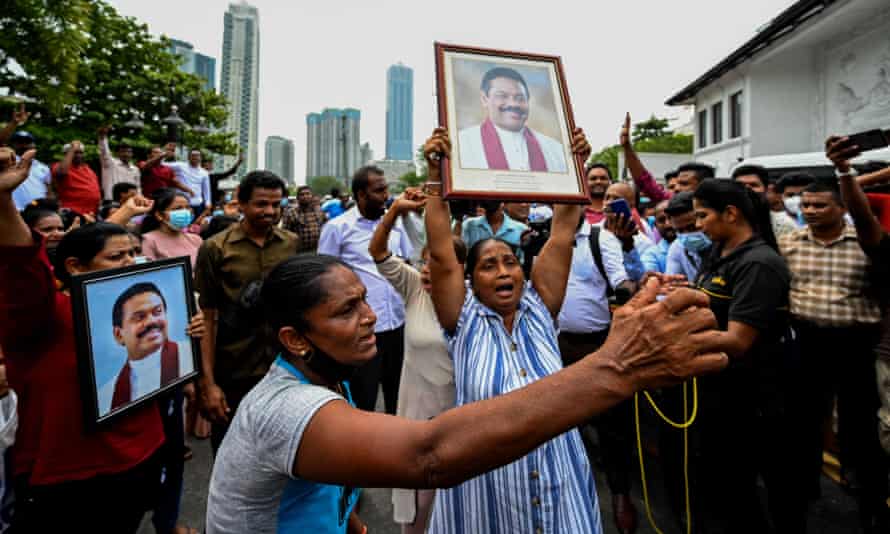 Pro-government supporters hold outgoing prime minister Mahinda Rajapaksa’s portrait while demonstrating outside his residence in Colombo.