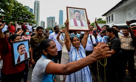 Pro-government supporters hold aloft a portrait of the outgoing prime minister, Mahinda Rajapaksa