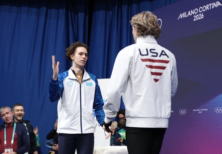 Gold medalist Mikhail Shaidorov of Kazakhstan shakes hands with Ilia Malinin after the finish.