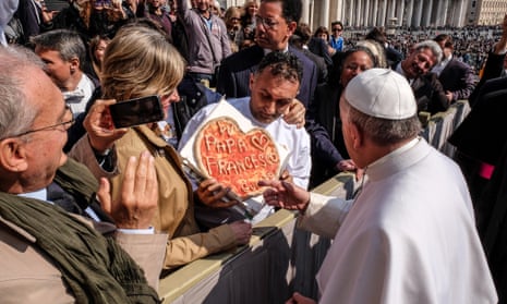Pope Francis is offered a specially decorated pizza.