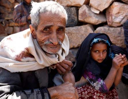 Yemeni Nasser Ahmad al-Qallam and his granddaughter gather to eat boiled leaves near their house at the mountain village of Bani al-Qallam, about 100km south-west of Sana’a, Yemen