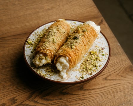 The osmalieyeh pudding at Kinz is 'delicate, not over-sweet and a gentle way to end' a meal. It looks like two filo cigars with pistachio on top.