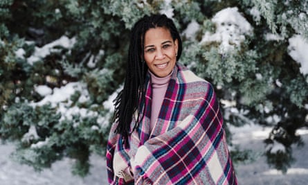 Hispanic woman wrapped in shawl at park during winter.