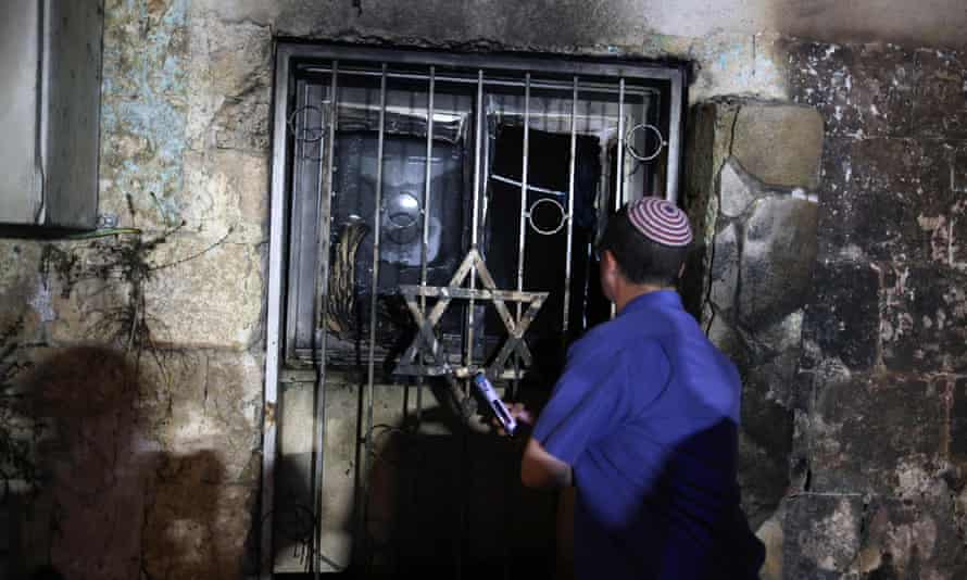 An Israeli man looks inside a synagogue after it was set on fire by Arab-Israelis in Lod.