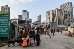 Against the backdrop of skyscrapers, homeless people rush “home” as curfew draws near during lockdown in Manila, the capital of the Philippines.