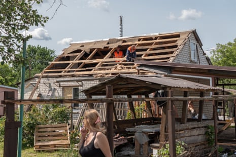 Municipal workers repair a roof of a house in Kharkiv heavily damaged by Russian shelling.