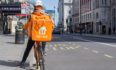 Just Eat courier rides along Piccadilly delivering takeaway food in central London