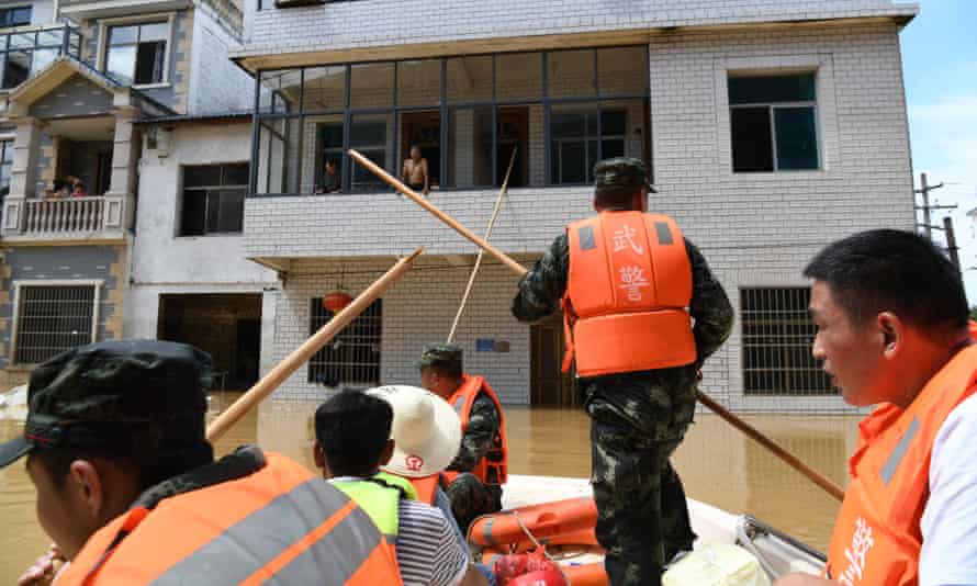Pelastajat toimittavat ruokaa kyläläisille, jotka ovat loukussa tulva-alueella Shangraossa Jiangxin maakunnassa.
