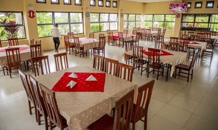 Windowed room with dining tables and chairs on a white tiled floor