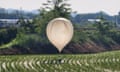 A balloon carrying various objects and believed to have been sent by North Korea is seen over a rice field at Cheorwon, South Korea