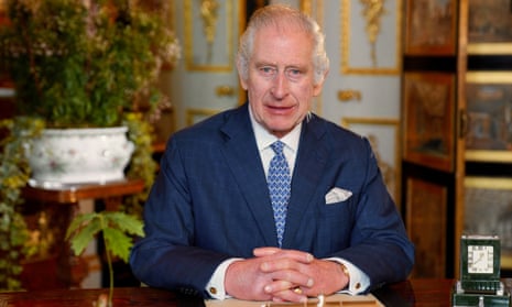 King Charles with hands clasped sitting at desk during the recording of his Commonwealth message at Windsor Castle