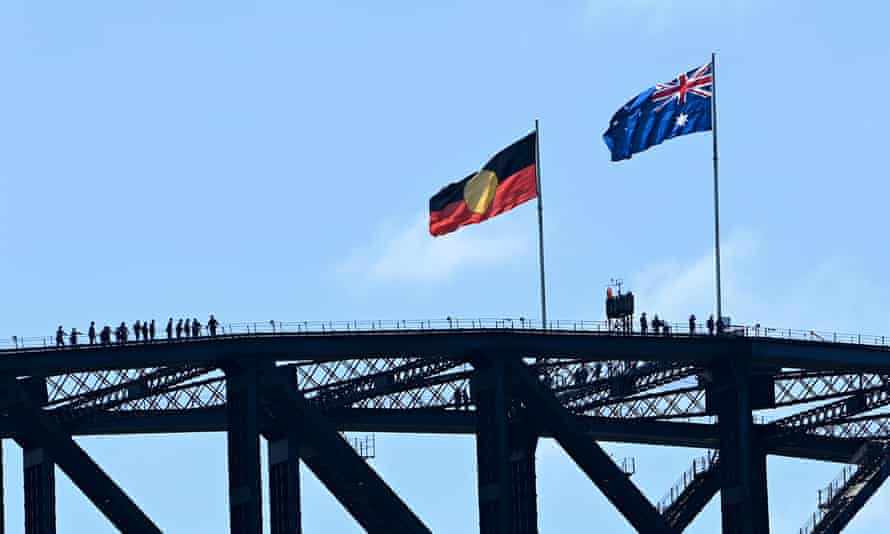 The Aboriginal and Australian national flags are seen on top of the Sydney Harbour Bridge during Australia Day 2022 celebrations in Sydney.