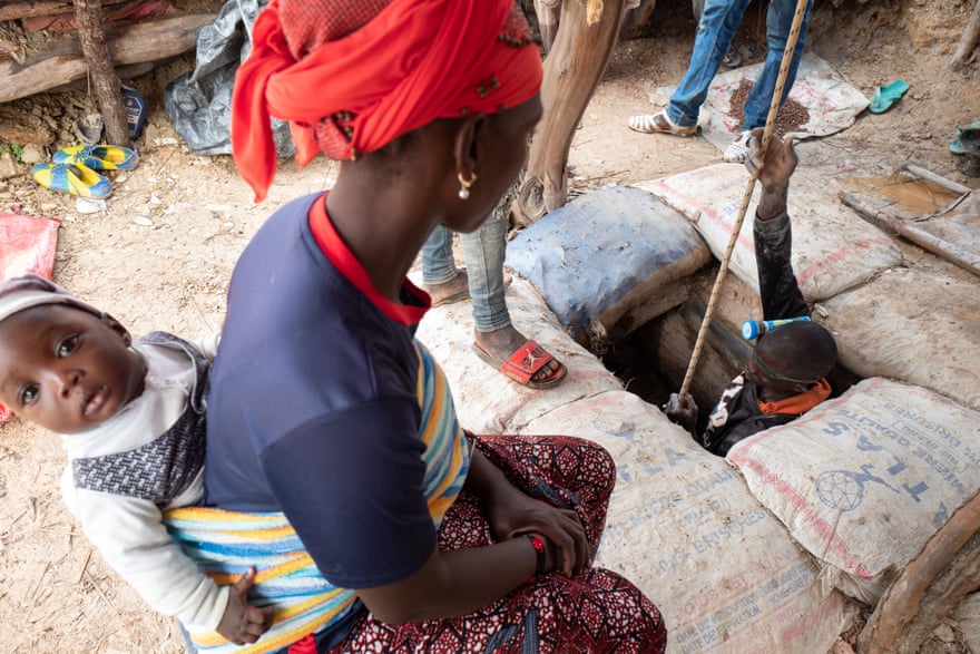 Woman and child watch husband go down mine shaft