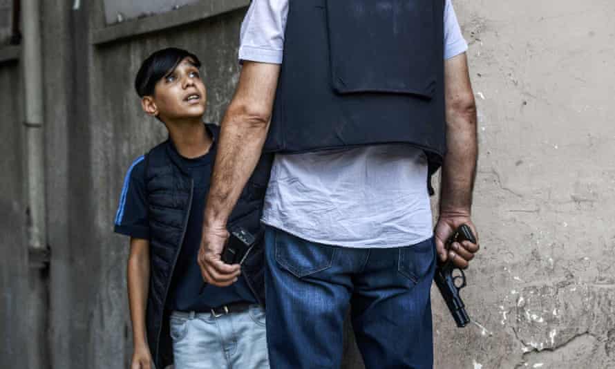 A Turkish policeman questions to a Kurdish boy in Diyarbakir.