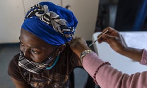 A woman is vaccinated against Covid-19 at the Lenasia South Hospital, near Johannesburg on 1 December as South Africa records a surge in cases.