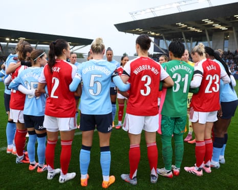 The players of Arsenal and Manchester City form a huddle as they wear black armbands in honour of the victims of the Heaton Park Synagogue attack