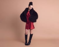 Model in black faux fur jacket, red mini dress and knee length back boots