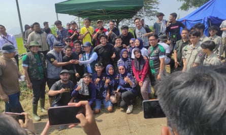 Voluntários na limpeza da barragem de Bandung tiram fotos com o grupo TikTok indonésio Pandawara (em preto).