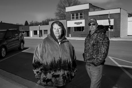 Two people in hoodies stand for a portrait outdoors