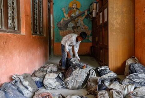 Student Uma Shah looks for his school bag inside the flood-damaged Bageshwori Secondary School, in Dhading district, Nepal.