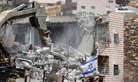 An Israeli army excavator demolishes a building in the Palestinian village of Sur Baher