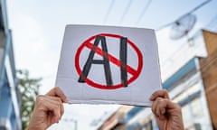 a person holds a sign with 'AI' crossed out in red