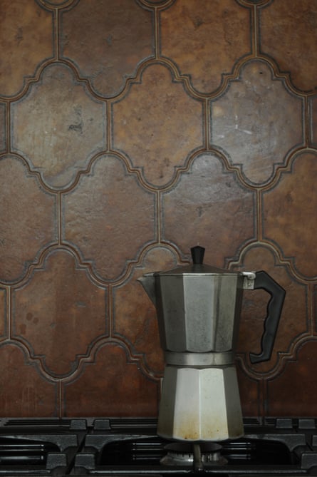 A coffee pot on top of the hob with a spanish tile splashback in the background
