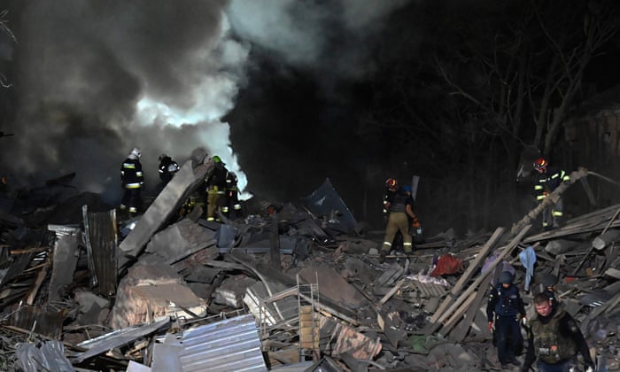 Rescue workers inspect the site of a destroyed hostel as a result of a missile strike in Kharkiv late on 17 August