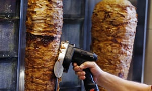 A man slices cuts of meat from a doner spit in Frankfurt, Germany.