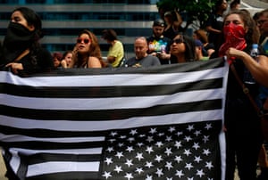 Demonstrators in Chicago hold a black American flag upside-down as they protest against white supremacy groups and Donald Trump