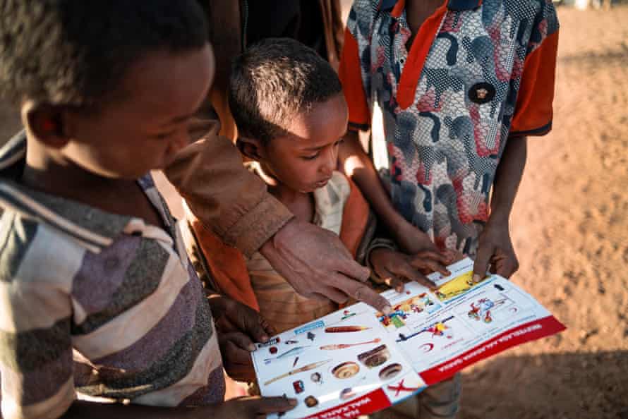 Three children read a school book