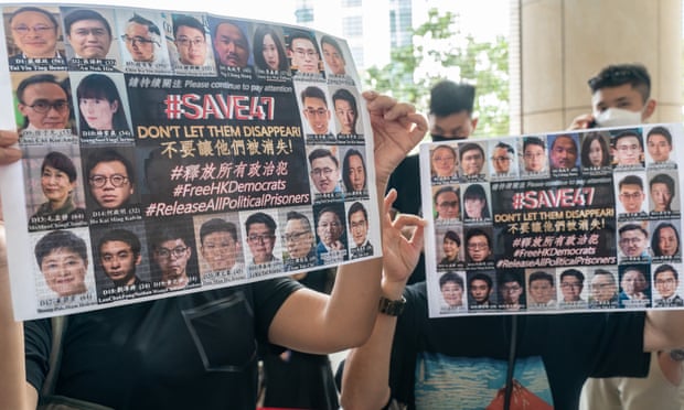 Supporters hold signs featuring images of some of the 47 pro-democracy activists outside the magistrates court in Hong Kong