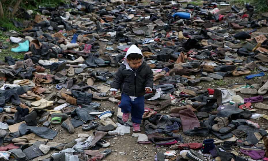 A boy walks among pairs of shoes at the premises of an NGO next to the Moria camp for refugees and migrants, on the island of Lesbos, Greece, 9 March 2020.