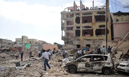 People walk among the rubble of the hotel attack in Mogadishu.