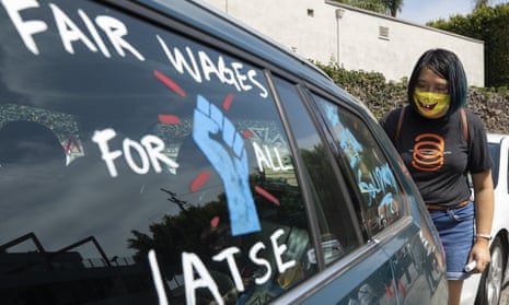 Crystal Kan, a storyboard artist, draws pro-labor signs on cars of union members during a rally at the Motion Picture Editors Guild IATSE Local 700 on Sunday in Los Angeles.