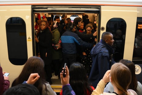 Commuters board a crowded train at Stratford Station in London on November 10, 2022.