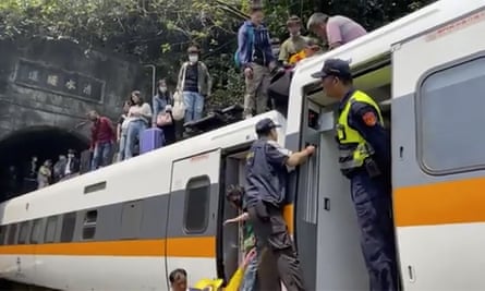 Passengers are helped to climb out of the derailed train
