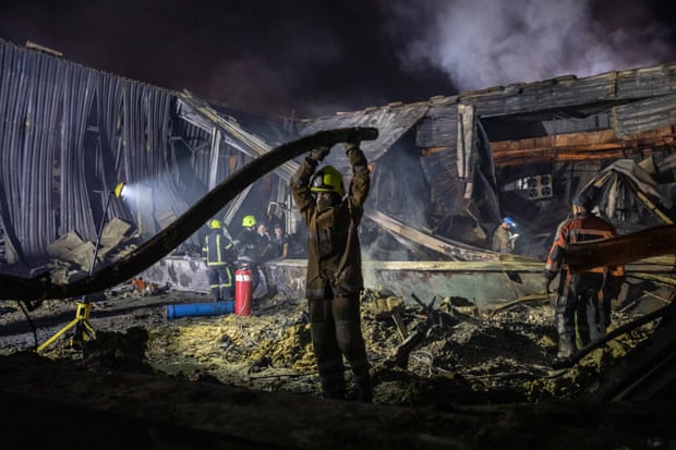 Firefighters sift through the wreckage of the shopping centre in Kremenchuk