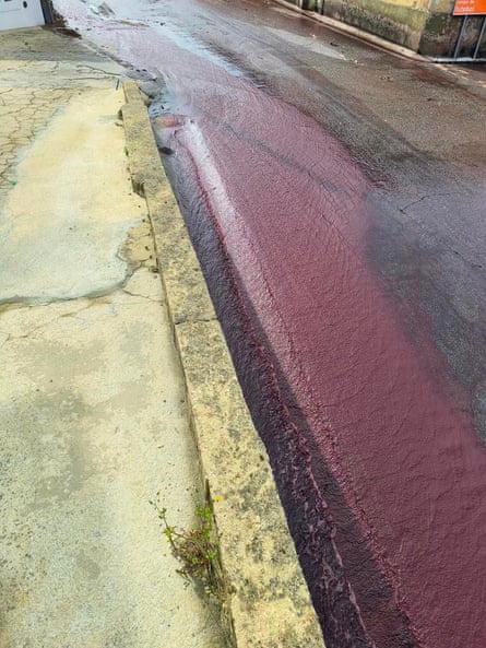 Um rio de vinho tinto corre por uma rua em Livera, Portugal.