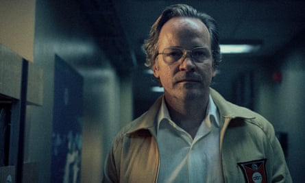 man wearing glasses, tan jacket and white button-down