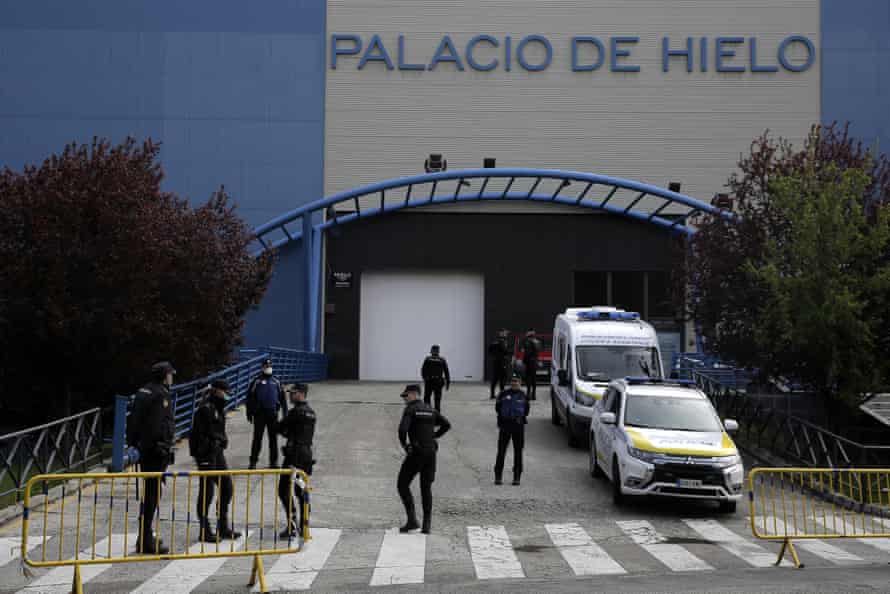 Police officers stand in front of an ice rink turned into a temporary morgue in Madrid, Spain, on 24 March.