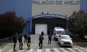 Police officers stand in front of Madrid’s ice rink, which has been turned into a temporary morgue