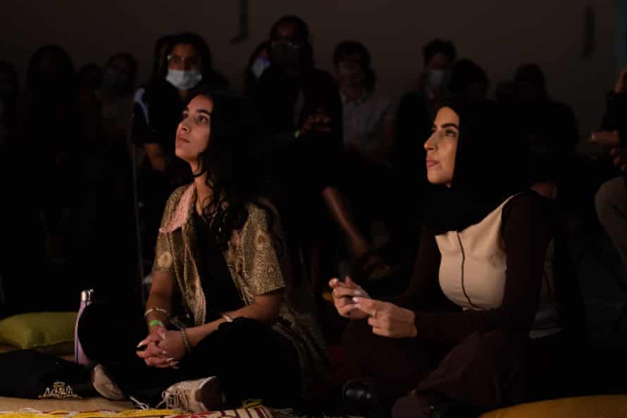 A captivated audience click their fingers in appreciation